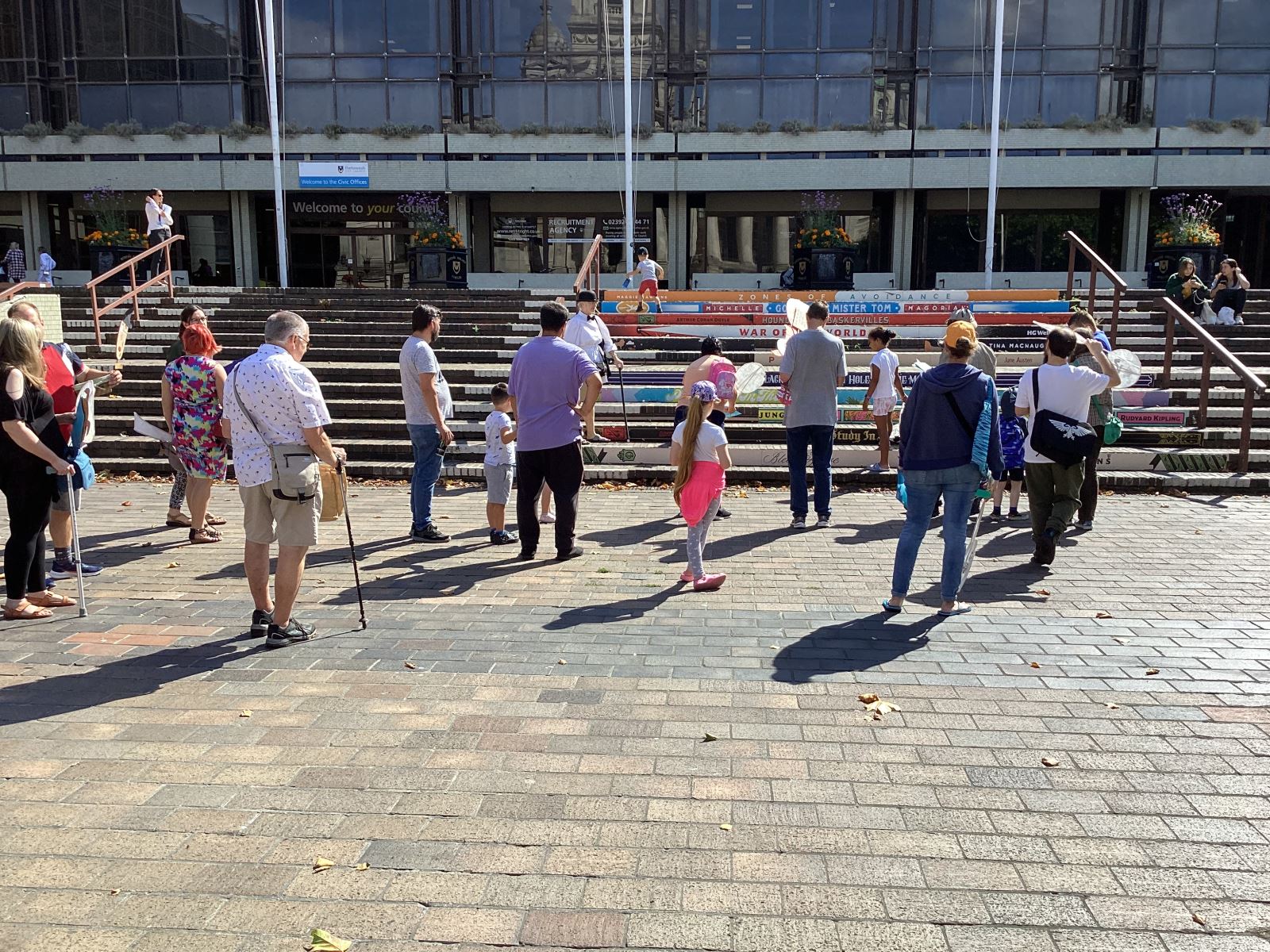 Group of people in front of the steps opposite Portsmouth guildhall